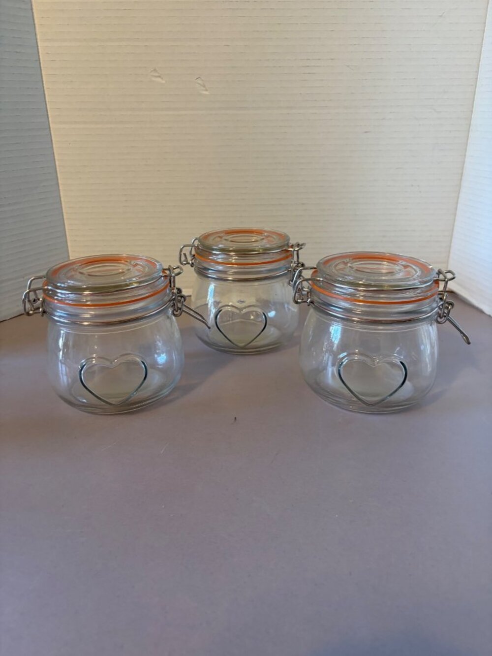 Set Of 3 Small Clear Glass Jars With Heart Design & Orange Seal Hinged Lids 4" T